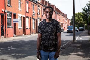 Participant Epie stands on a redbrick Leeds street