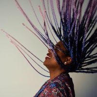 Participant Axelle tosses their braided hair in the air.